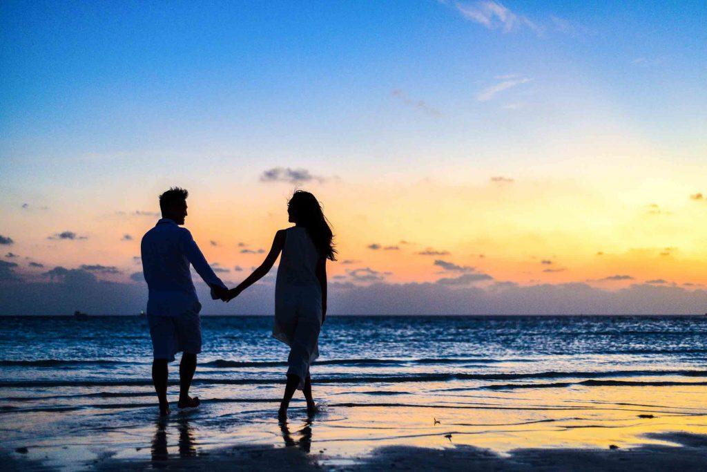 Couple walking hand in hand on the beach Romantic Saint Valentine´s day